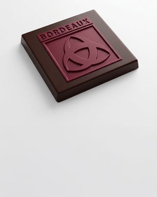 Carré de chocolat noir estampillé Bordeaux, emblème de l’agence Chocolat Noir